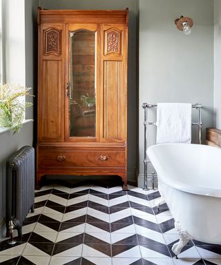 Vintage bathroom with black and white flooring and vintage wood closet