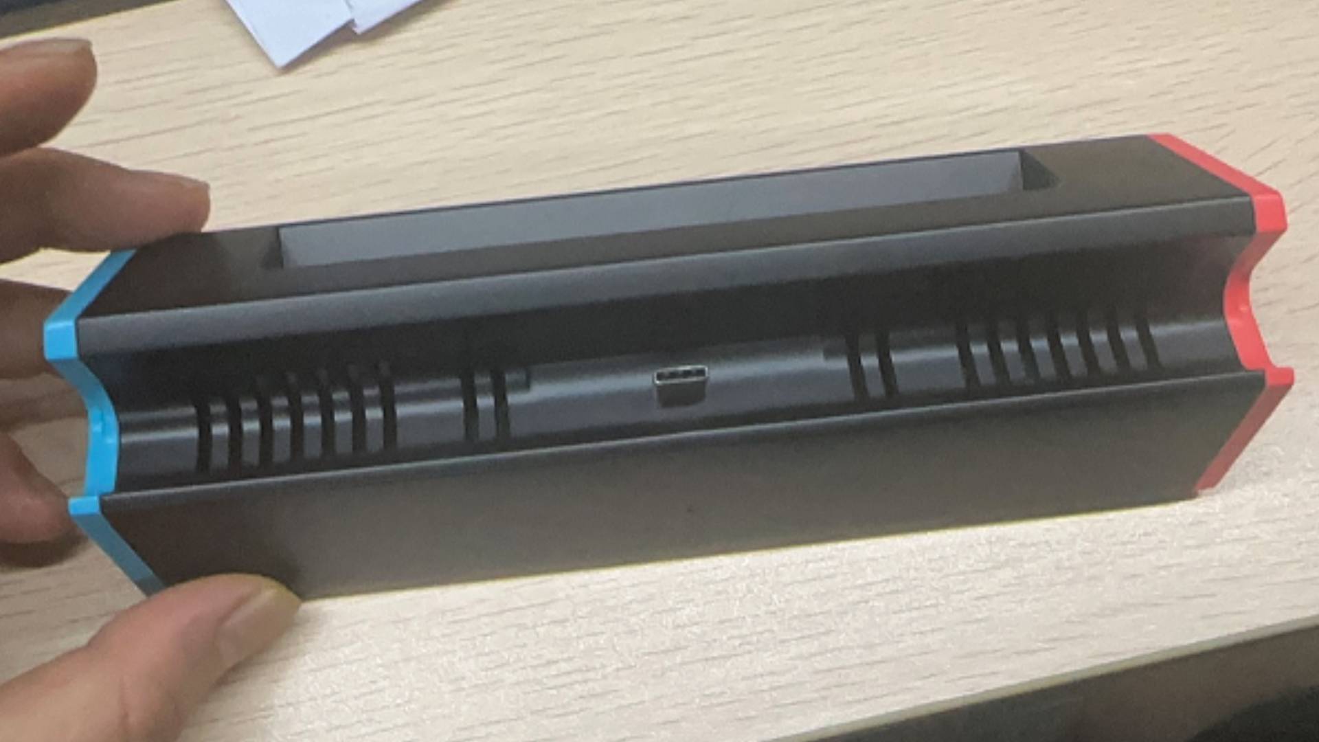 Hand holding SIWIQU Switch 2 dock with added air vents.