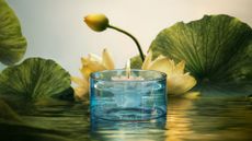 A floating scented candle in a blue glass vessel