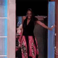 A GIF of a woman excitedly arriving through a door