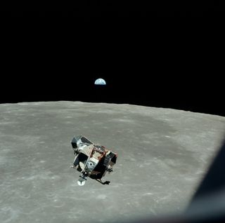 A photo of the Apollo 11 flying over the Moon with Earth far in the distance