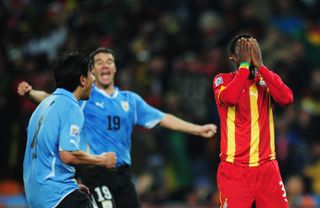 Ghana's Asamoah Gyan (right) holds his head after missing a penalty against Uruguay at the 2010 World Cup.