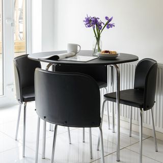 dining room with white interior and black round table with chairs