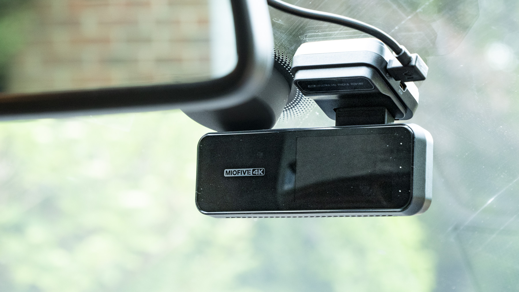 Miofive Dual Dash Cam front camera attached to a windscreen view from driver's seat