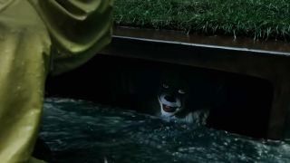 Pennywise in It looking up from a storm drain.