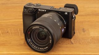 Et kamera av typen Sony A6100 på en bordplate med 16–70 mm-objektiv.