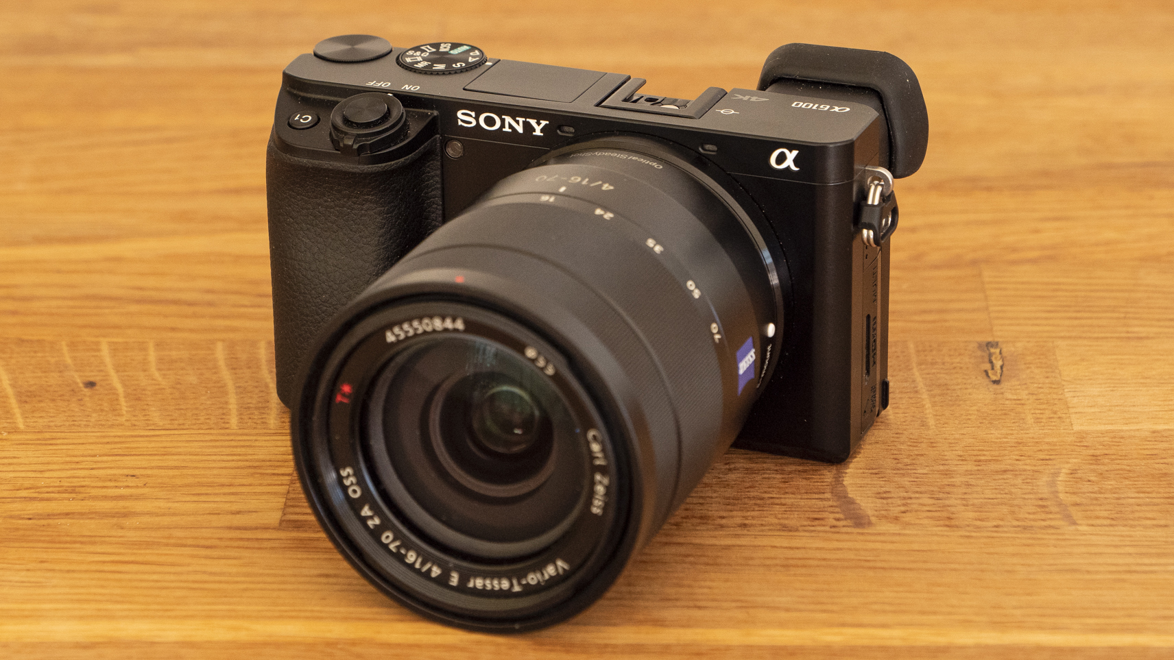 The Sony A6100 camera sat on a table with the 16-70mm lens