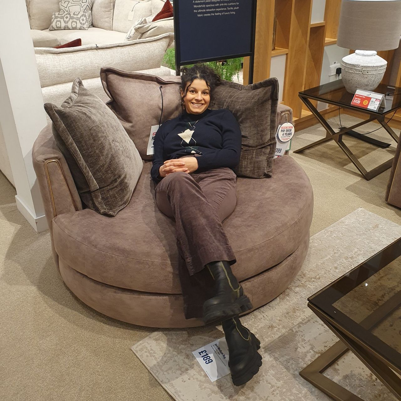 Sara sitting on a large DFS swivel snuggle chair