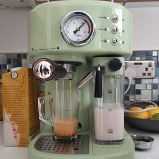 A green Swan Retro One Touch Espresso Machine making a coffee with milk