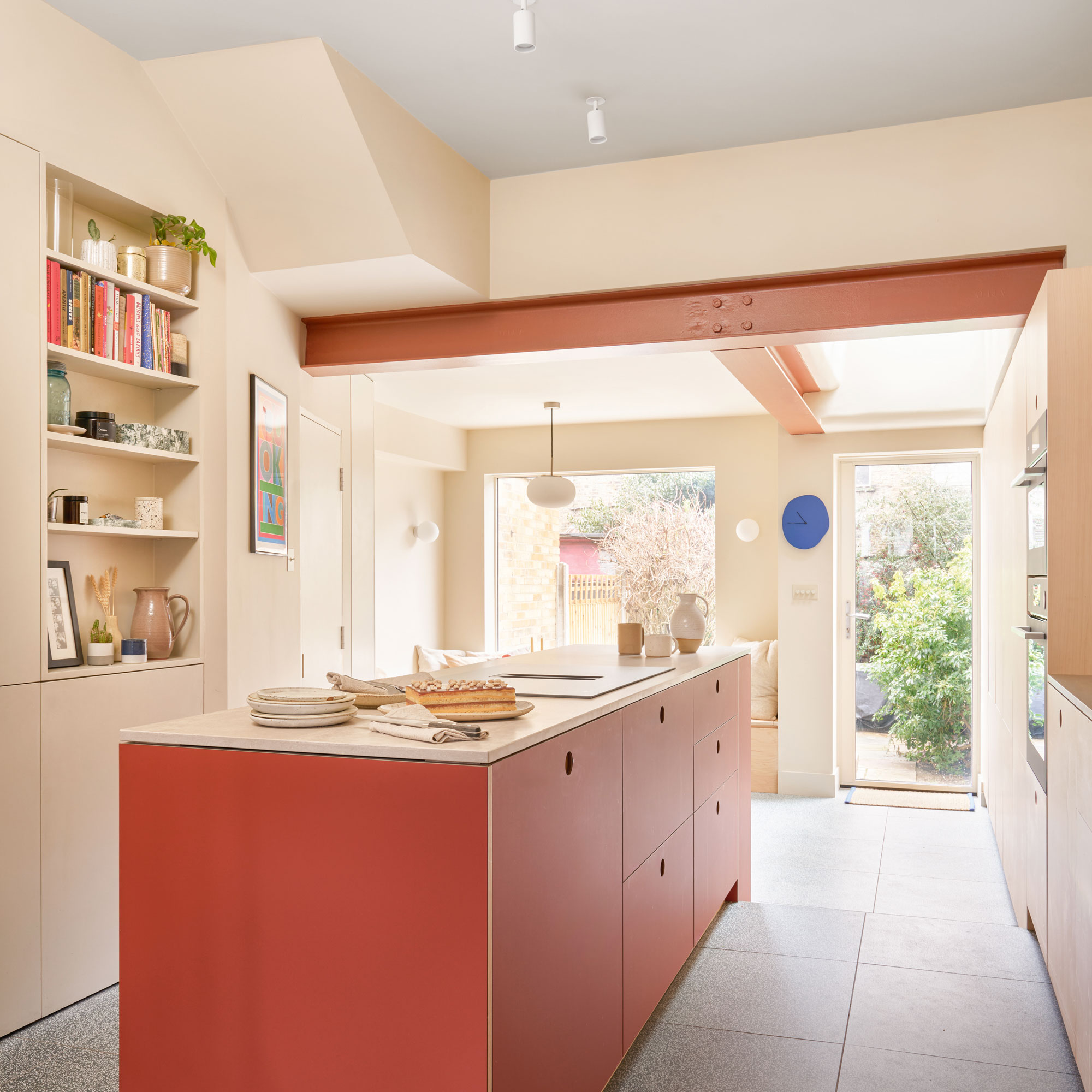 White kitchen walls, terracotta kitchen island and a terracotta beam