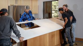 Workers installing a kitchen worktop