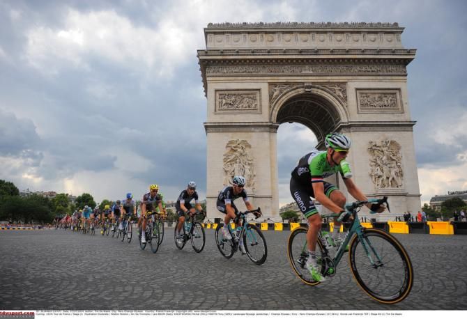 Riders pass the Arc de Triomphe