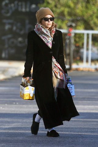 Mary-Kate Olsen portant un long manteau noir et des chaussures en fourrure