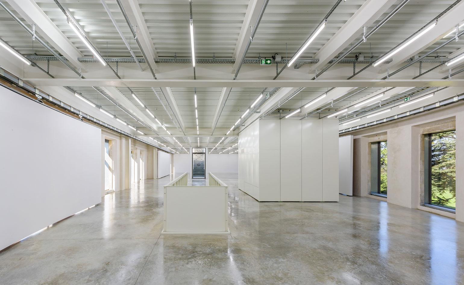 Full length view of exhibition hall with light flooding in through the large windows on both sides