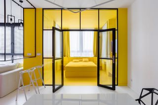 small bedroom organization ideas with an all-yellow bedroom and glass panels surrounding it