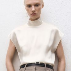 Woman wears silk cream top