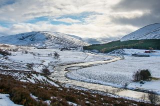 A valley in the Cairngorms in Scotland covered in snow
