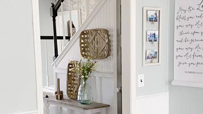 a modern hallway with a herringbone-style stencil wall, and pictures and art in the foreground