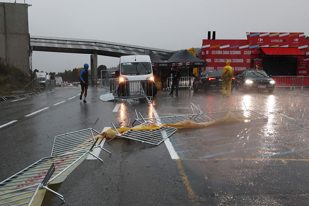 Fallen barriers at the finish as rain pours down