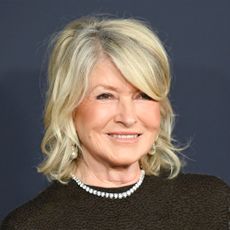 Martha Stewart at the Pre-Grammy Gala wearing black against dark background
