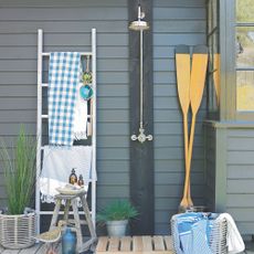 Towels hanging on rack in garden next to wooden oars