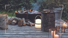 Garden decking with firepit and candles burning to suggest how to use ash in your garden