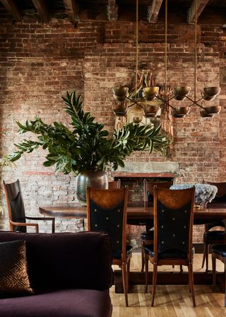 A dining room with exposed brickwork wall