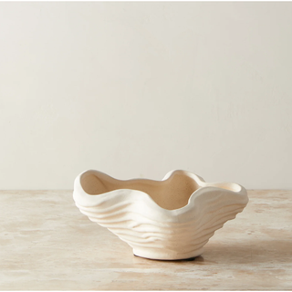 cream stoneware bowl with wrinkled rim and ridged detail on the outside