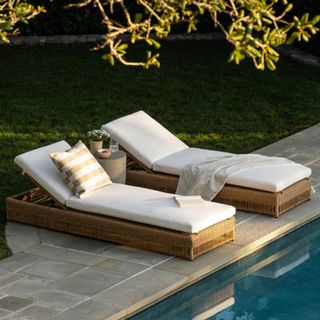 Two Goodwin Wicker Pool Chaises next to a swimming pool