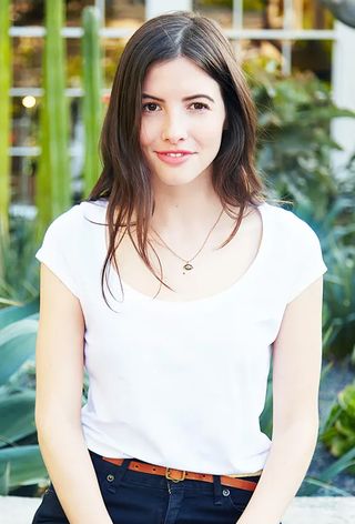 a close-up photo of an editor wearing a white t-shirt and jeans with a no-show bra
