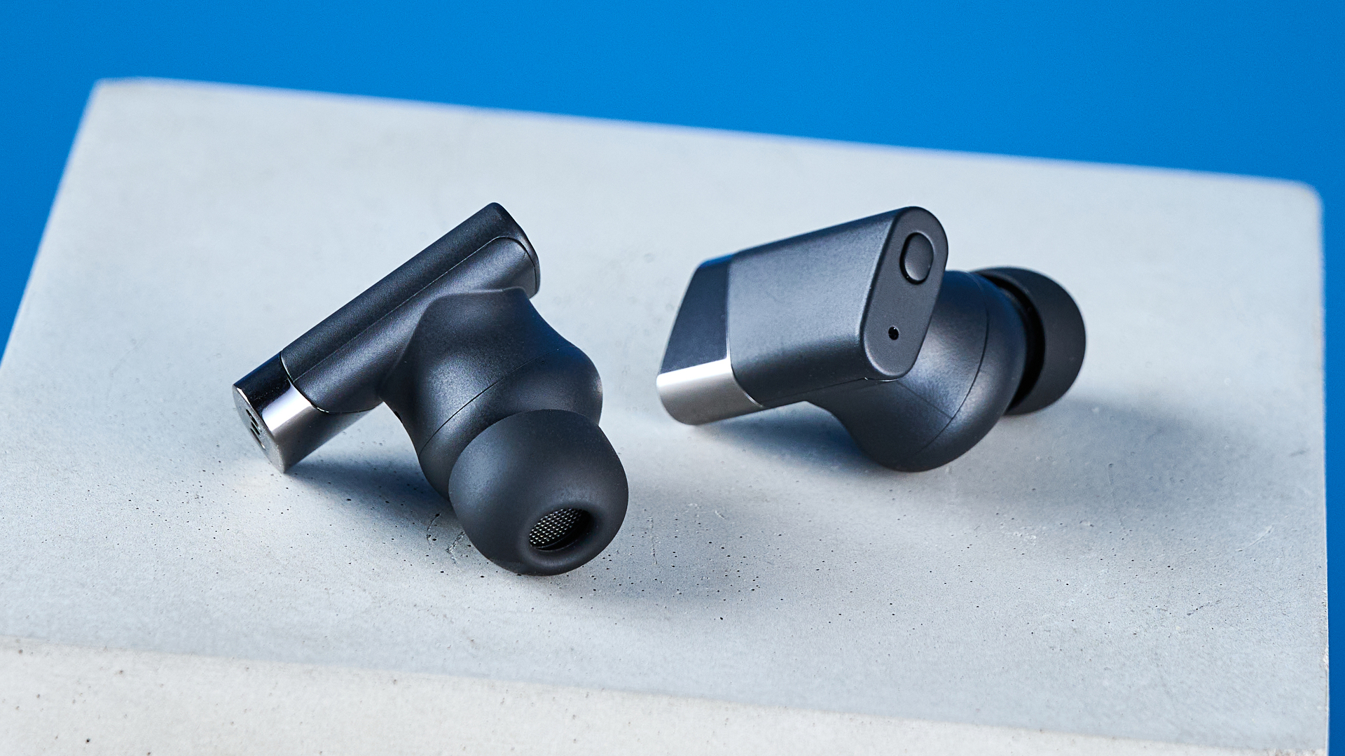 A pair of black Status Pro X wireless earbuds