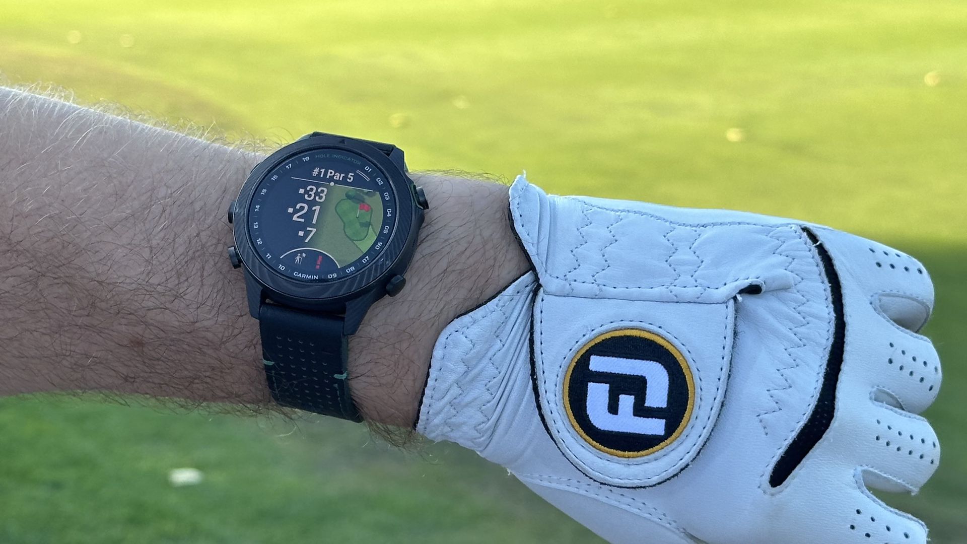 El Garmin MARQ Golfer (Gen 2) en una muñeca en el campo de golf