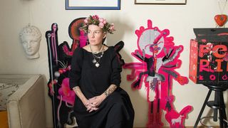 Are NFTs art? A photo of the artist Varvara Alay sat amidst some flowers and artwork