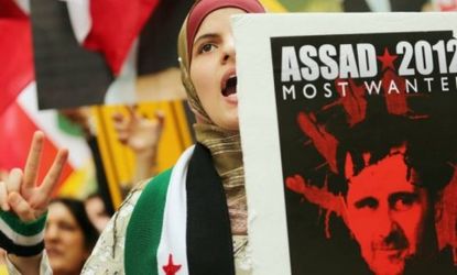 A protester in New York City holds a sign against Syrian President Bashar al-Assad: On Wednesday bomb attacks and firefights left more than 300 dead in Syria. 