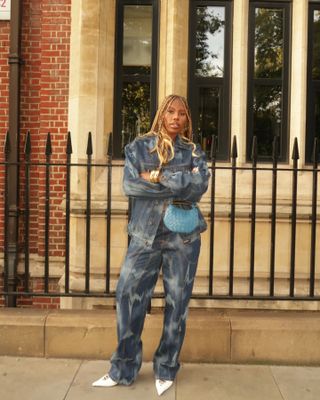 Woman wearing a denim set with white pointed toe heels.