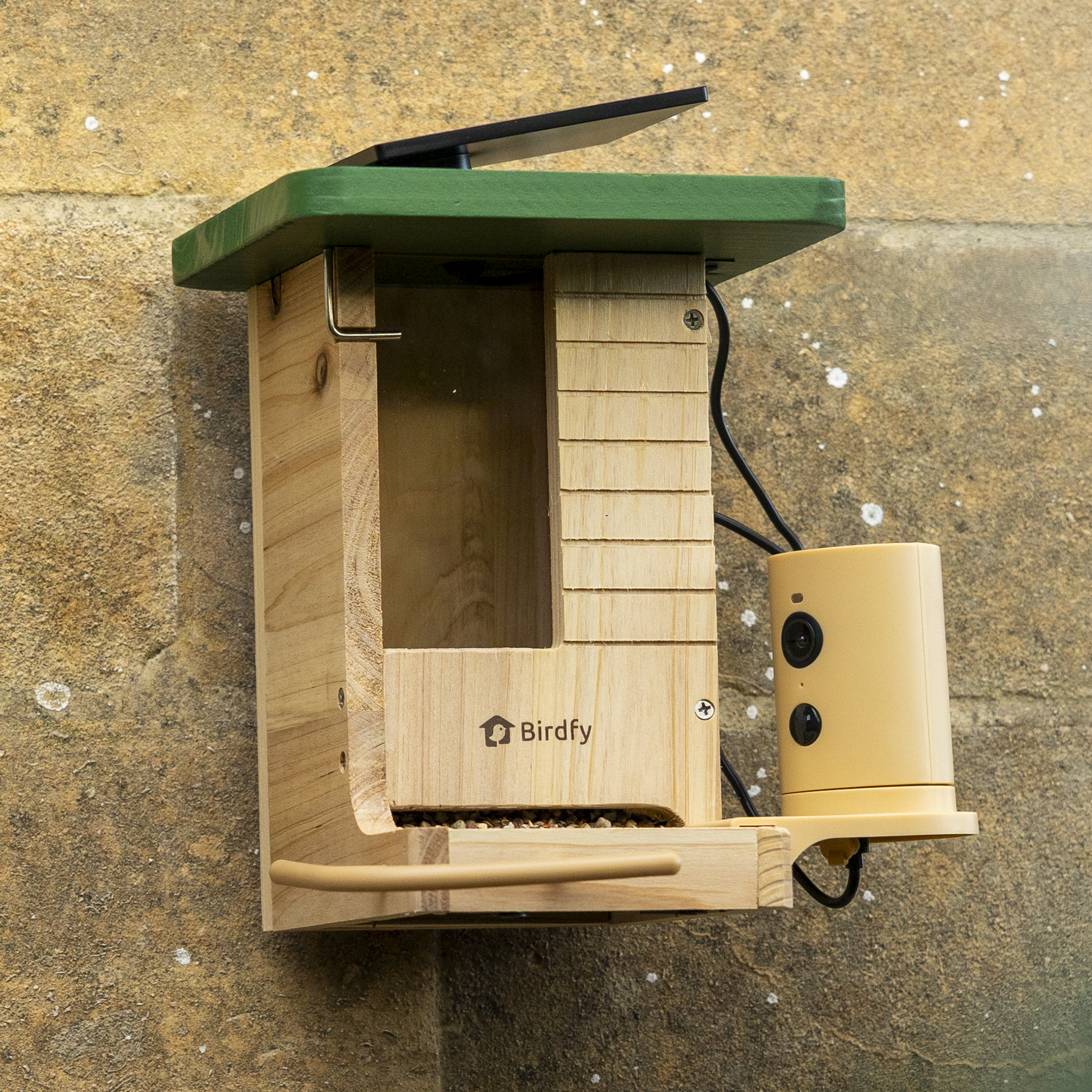 The Birdfy Wood feeder attached to a sandstone wall