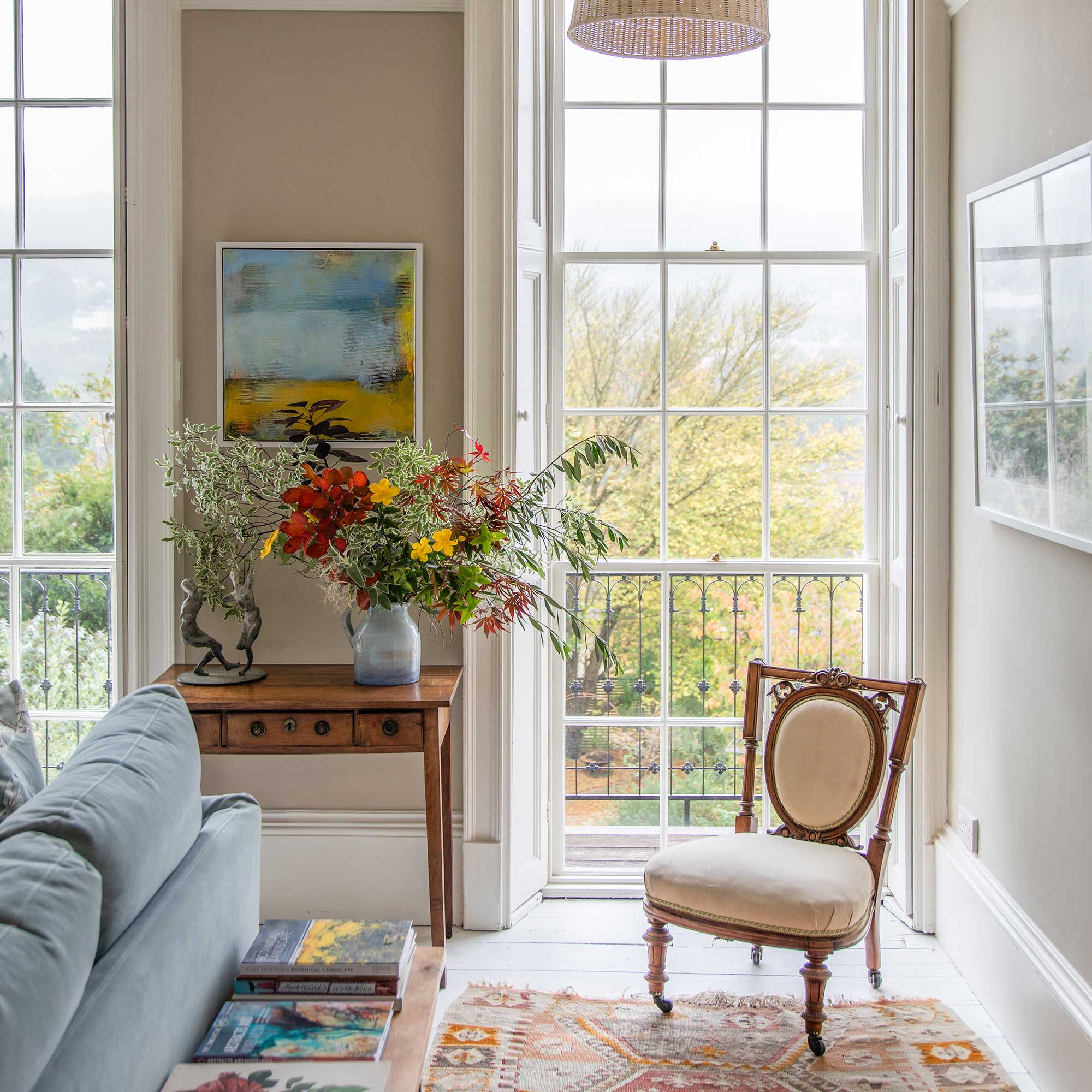 view towards large sash windows in a living room in georgian villa with mix of antique and new furniture