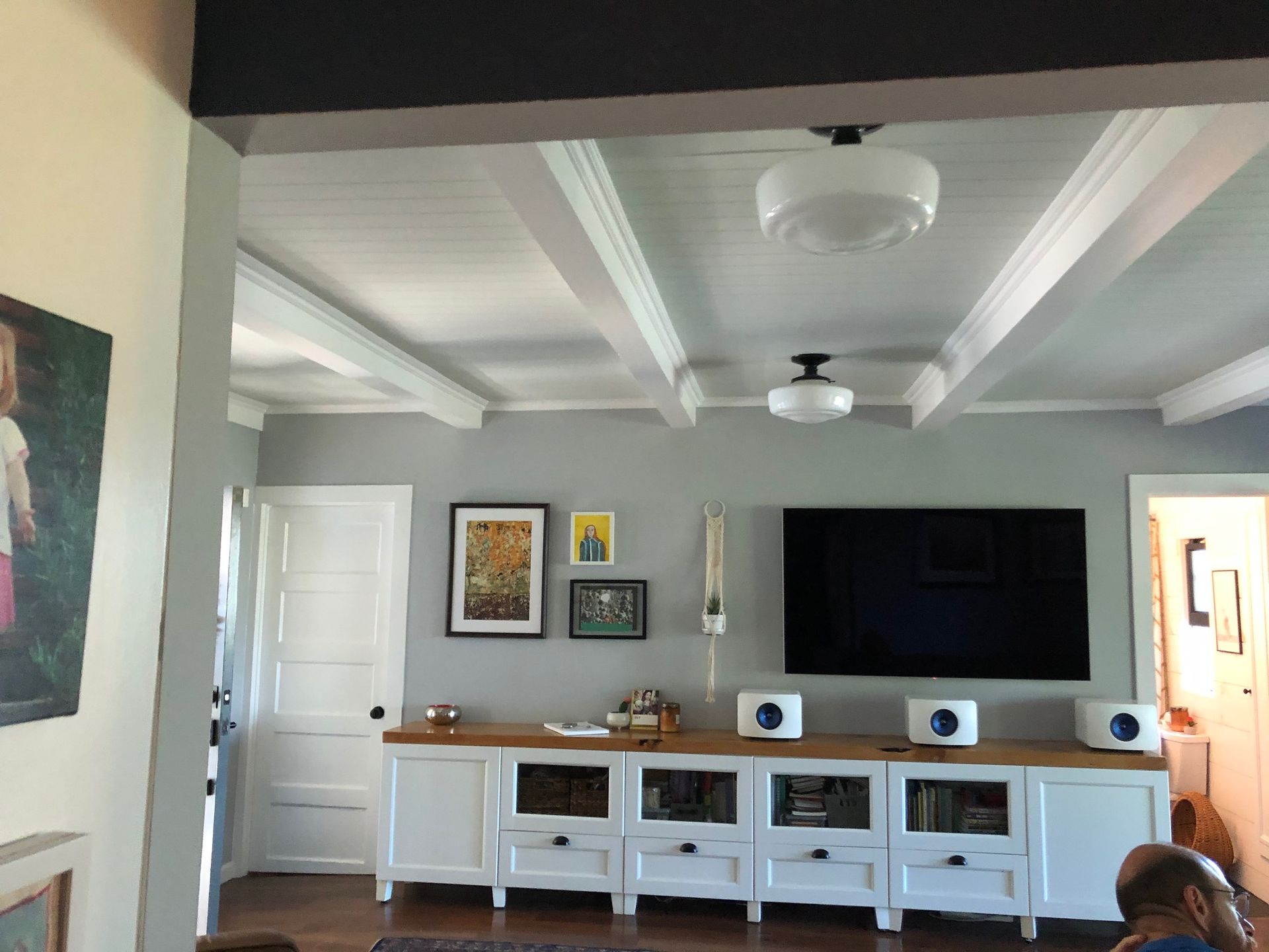 A dated living room with a white media unit and pale blue walls