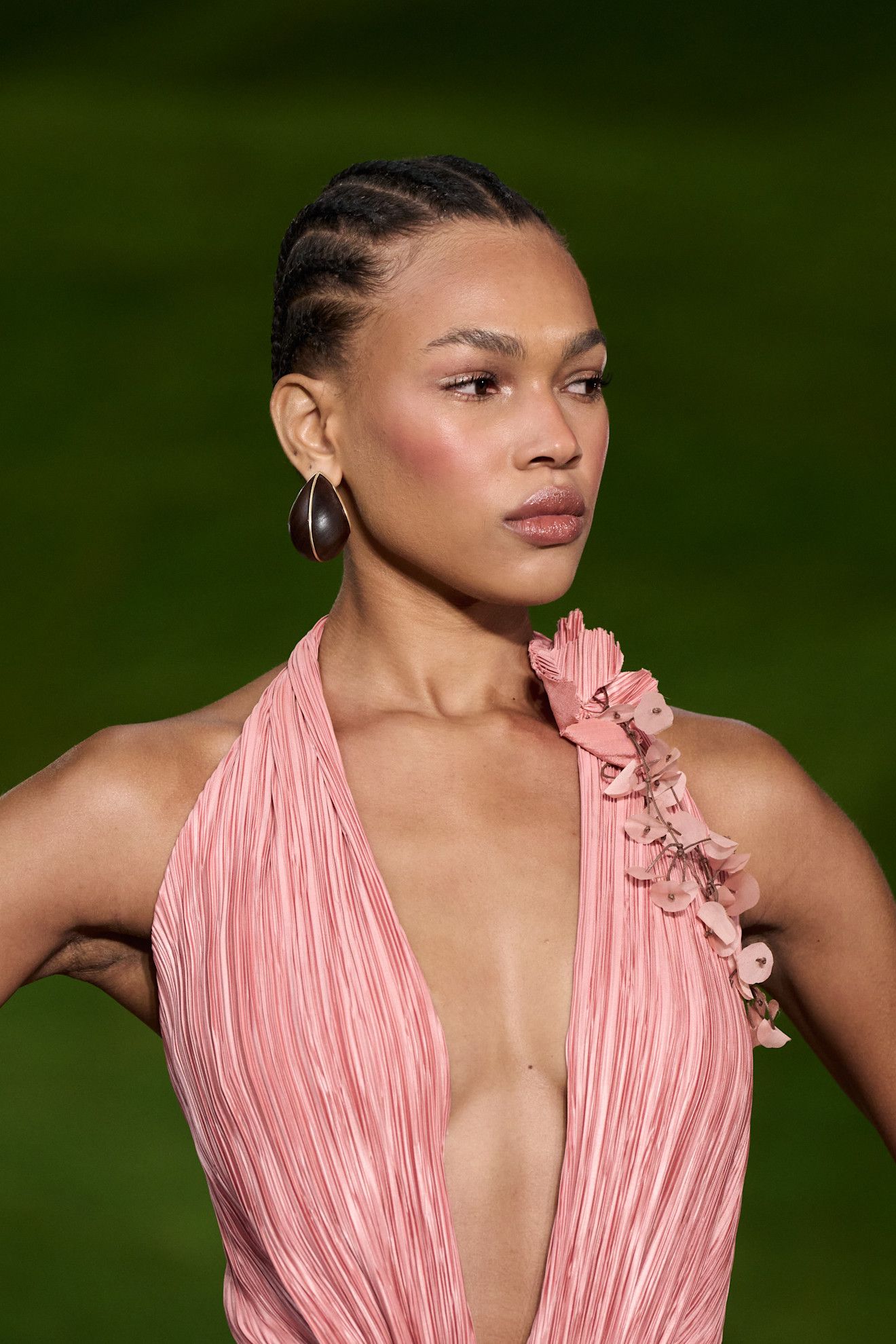 Lipgloss lids at Cult Gaia on a mode in a pink dress.