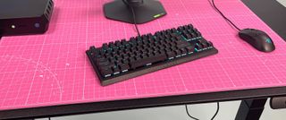 a black keyboard sitting on a pink mat