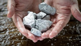 Miners hold in their hands platinum or silver or rare earth minerals found in the mine for inspection and consideration