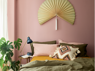 A pink toned bedroom with a wall hanging