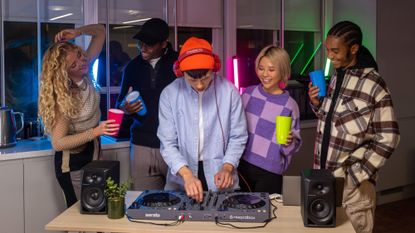 A DJ using the Pioneer DDJ-FLX6-GT is surrounded by happy partygoers
