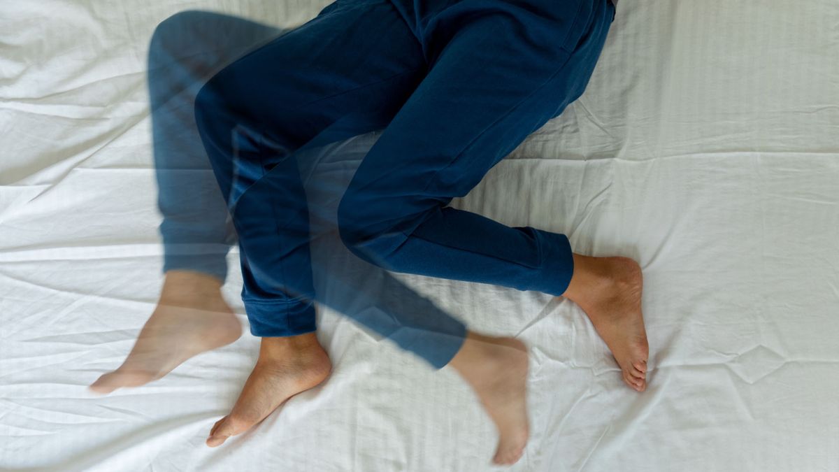 woman laying on her bed with restless legs syndrome