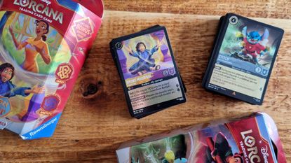 Disney Lorcana boxes and card decks lying on a wooden surface
