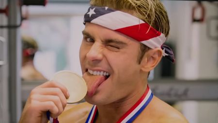 Zac Efron licking an Olympic medal in Baywatch 2017. 