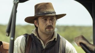 Spencer Dutton in hat standing outside someone's vehicle in 1923