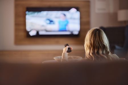 Woman pointing remote at TV