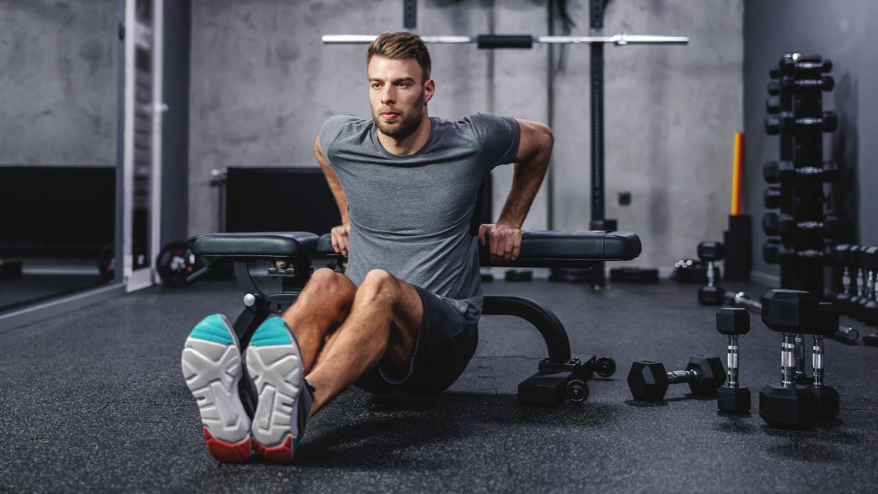 Man doing tricep dips on weight bench