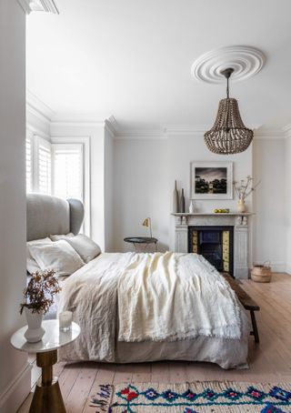 White bedroom with boho touches and large chandelier